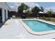 Inviting backyard pool with a light stone surround and lush landscaping offers a refreshing oasis at 821 Silver Springs Nw Ter, Port Charlotte, FL 33948