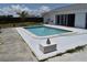 Backyard pool featuring light stone surround, an inviting oasis near sliding glass doors for easy access at 821 Silver Springs Nw Ter, Port Charlotte, FL 33948