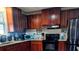 Well-appointed kitchen featuring dark wood cabinetry, granite countertops, and stainless steel appliances at 9790 66Th N St # 100, Pinellas Park, FL 33782