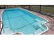 Screened in pool with clear blue water and built in steps with metal hand rails in an outdoor setting at 2580 68Th S Ave, St Petersburg, FL 33712