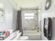 Bright bathroom featuring marble-look tiled walls, a decorative mirror, and a shower-tub combo at 5710 92Nd N Ter, Pinellas Park, FL 33782