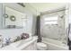Bright bathroom featuring marble-look tiled walls, a lighted mirror, and a shower-tub combo at 5710 92Nd N Ter, Pinellas Park, FL 33782