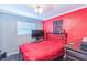 Bedroom features a vibrant red accent wall, wood floors, and comfortable furnishings at 5710 92Nd N Ter, Pinellas Park, FL 33782