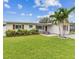 Well-maintained home with vibrant landscaping, a lush green lawn, and a charming front facade at 5710 92Nd N Ter, Pinellas Park, FL 33782