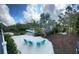 Secluded backyard with a beachside seating area, waterfront views, and mature tropical landscaping at 608 Bittner Blvd, Nokomis, FL 34275