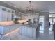 Well-equipped kitchen with an island, marble countertops, custom cabinets, and modern stainless steel appliances at 608 Bittner Blvd, Nokomis, FL 34275