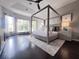 Stunning main bedroom boasting a four-poster bed, tray ceiling and light-filled sitting area at 608 Bittner Blvd, Nokomis, FL 34275