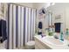 Bright bathroom featuring a single sink vanity and a shower with a striped curtain at 232 Countryside Key Blvd, Oldsmar, FL 34677