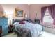 Cozy bedroom with pink walls, complemented by a colorful bedspread and soft natural lighting at 232 Countryside Key Blvd, Oldsmar, FL 34677