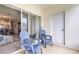 Relaxing patio with blue Adirondack chairs and sliding glass doors leading to the living area at 232 Countryside Key Blvd, Oldsmar, FL 34677