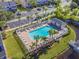 Aerial view of community pool area with palm trees, lounge chairs and adjacent parking at 232 Countryside Key Blvd, Oldsmar, FL 34677