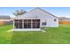 Backyard view with white exterior and a screened in porch, perfect for outdoor living at 24237 Rolling View Ct, Lutz, FL 33559