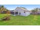 Backyard view showing the house's exterior, a screened-in porch, and a spacious lawn at 24237 Rolling View Ct, Lutz, FL 33559