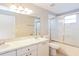 Bathroom featuring double sink vanity, large mirror, and glass enclosed shower and tub at 24237 Rolling View Ct, Lutz, FL 33559