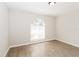 Bright bedroom featuring a large window and wood-look floors, bathed in natural light at 24237 Rolling View Ct, Lutz, FL 33559