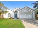 Charming single-story home featuring a well-maintained lawn and attached two-car garage at 24237 Rolling View Ct, Lutz, FL 33559
