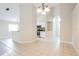 Open kitchen with white cabinets, stainless appliances and tiled floor adjacent to living room at 24237 Rolling View Ct, Lutz, FL 33559