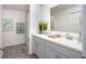Bright bathroom featuring double sinks, a large mirror, and wood look floors at 16408 Courlan Rd, Weeki Wachee, FL 34614
