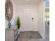 Bright entryway featuring wood-look flooring, white walls, decorative mirror, and a lovely accent table with potted plant at 16408 Courlan Rd, Weeki Wachee, FL 34614
