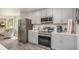 Modern kitchen with stainless steel appliances, granite countertops, and a breakfast bar overlooking the living area at 16408 Courlan Rd, Weeki Wachee, FL 34614