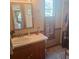 Bathroom vanity with a rustic wooden base, a window, and decorative wall accents at 5148 Cyril Dr, Dade City, FL 33523