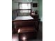 Cozy bedroom featuring natural light, wood-framed bed and nightstand and a chest at the foot of the bed at 5148 Cyril Dr, Dade City, FL 33523