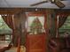 Cozy living room with wood paneling, large windows with decorative curtains and leather sofa at 5148 Cyril Dr, Dade City, FL 33523