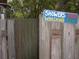 Rustic outdoor shower with privacy fence and humorous signage at 5148 Cyril Dr, Dade City, FL 33523