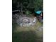 The aerial view reveals an attractive outdoor firepit with a sitting area amid lush green landscape at 5148 Cyril Dr, Dade City, FL 33523