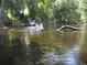 View of a Personal kayaking down the river surrounded by lush greenery and aquatic foliage at 5148 Cyril Dr, Dade City, FL 33523