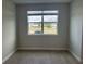 A bright, empty room with wood-look tile flooring and a large window at 7677 Deer Valley Circle, Tampa, FL 33635