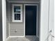 A modern front door with dark finish and neutral-tone siding for a welcoming entry at 7677 Deer Valley Circle, Tampa, FL 33635