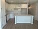 White kitchen with center island, modern appliances, and stylish pendant lighting at 7677 Deer Valley Circle, Tampa, FL 33635