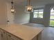 Bright living space with wood-look tile flooring, modern lighting, and a sliding glass door at 7677 Deer Valley Circle, Tampa, FL 33635