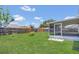 Large, green backyard with a wooden fence and a screened patio at 205 Island Water Way, Apollo Beach, FL 33572