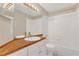 Bright bathroom with a large mirror and wood counter over a white vanity, and a shower/tub combo at 205 Island Water Way, Apollo Beach, FL 33572
