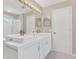 Modern bathroom featuring dual sinks, a white vanity, and a glass-enclosed shower at 205 Island Water Way, Apollo Beach, FL 33572