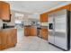 Well-lit kitchen features stainless steel appliances, wood cabinetry, and tile flooring at 205 Island Water Way, Apollo Beach, FL 33572