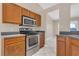 The kitchen features stainless steel appliances and wood cabinetry, complemented by tile flooring at 205 Island Water Way, Apollo Beach, FL 33572