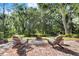 Spacious backyard area includes two wooden chairs and a stone fire pit for outdoor enjoyment at 36846 Perry Ct, Dade City, FL 33525