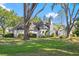 Rear exterior view of the home, featuring well-maintained lawn and mature trees at 36846 Perry Ct, Dade City, FL 33525