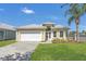 Charming home with a manicured lawn, lush landscaping and a white garage door at 6412 Coquina Island Cv, Apollo Beach, FL 33572
