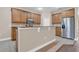 Stylish kitchen with ample wood cabinetry, a breakfast bar, and stainless-steel refrigerator at 6412 Coquina Island Cv, Apollo Beach, FL 33572