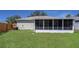 Spacious backyard featuring an enclosed sunroom and lush green lawn at 806 Rocky Mountain Ct, Valrico, FL 33594