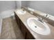 Bright bathroom featuring double sinks with a large mirror and tile flooring at 10768 Carloway Hills Dr, Wimauma, FL 33598