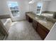 Bathroom with tiled floors, double vanity, and soaking tub at 10768 Carloway Hills Dr, Wimauma, FL 33598