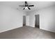 Cozy bedroom with ceiling fan, neutral carpet, and convenient access to two separate doorways at 10768 Carloway Hills Dr, Wimauma, FL 33598