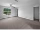 Neutral Primary bedroom boasts a ceiling fan, closet, and large sunny window with a view at 10768 Carloway Hills Dr, Wimauma, FL 33598