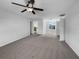 Bright bedroom features neutral carpet, ceiling fan, and sunny window with a view at 10768 Carloway Hills Dr, Wimauma, FL 33598