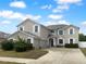 Two-story home featuring neutral stucco, white window trim, an arched entry, and a two car garage at 10768 Carloway Hills Dr, Wimauma, FL 33598